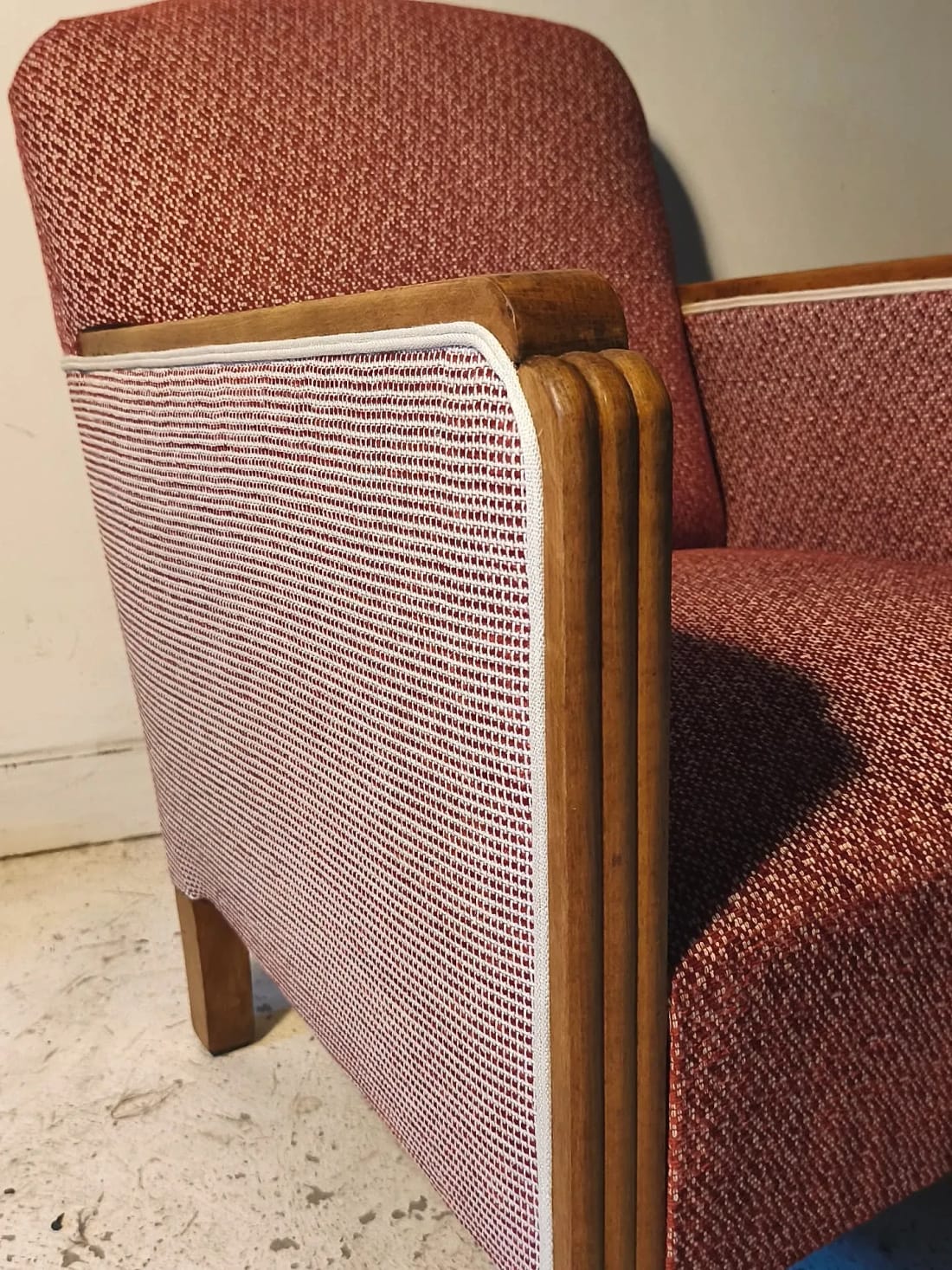 Détail de l&rsquo;arête d&rsquo;un fauteuil club, tissu terre cuite et double passepoil écru