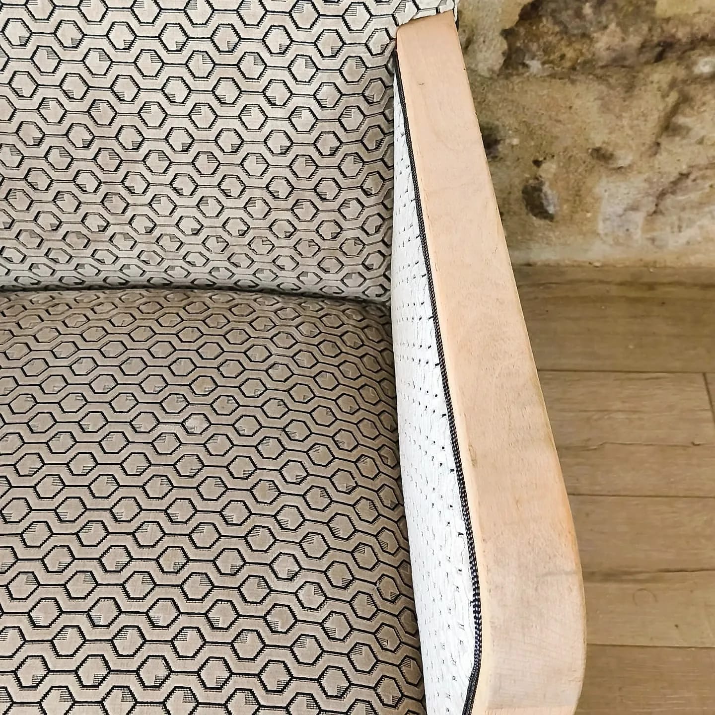 Détail du tissu à motif géométrique d&rsquo;un fauteuil en bois clair
