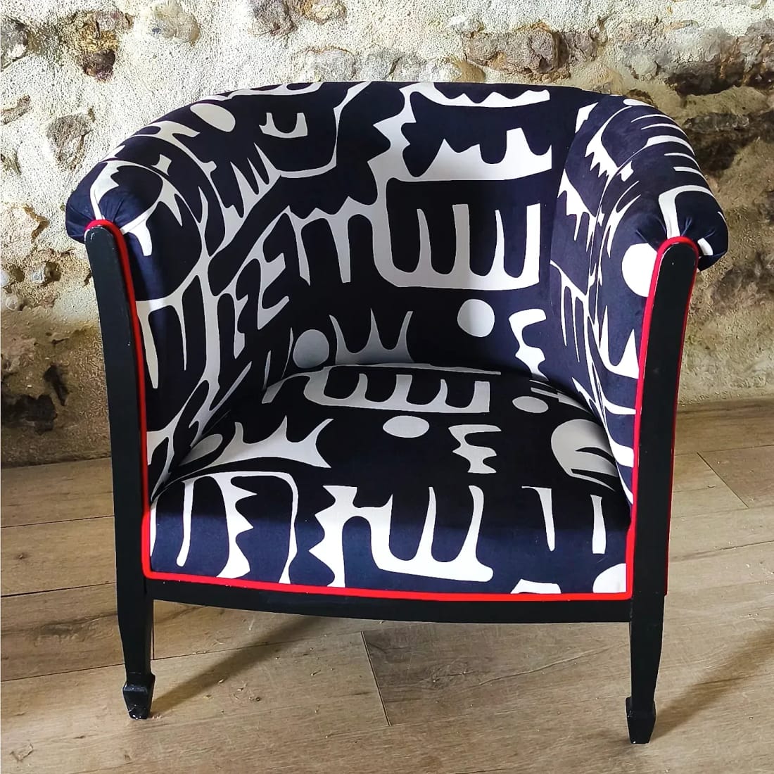 Fauteuil crapaud bleu marine à imprimé blanc, souligné d&rsquo;un passepoil rouge